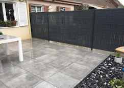 Clôture composite anthracite avec terrasse dallage par Infini Paysage