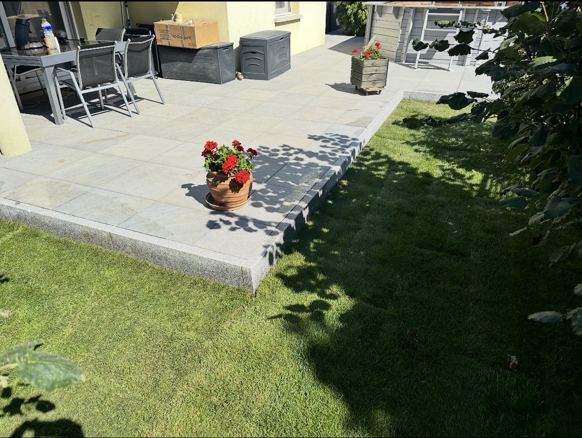 Aménagement paysager complet avec terrasse en pierre, pelouse et plantations