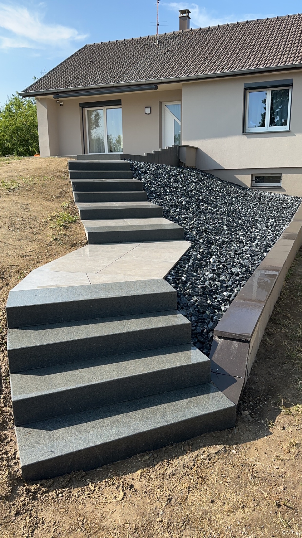 Escalier extérieur béton avec mur gabion en galets noirs